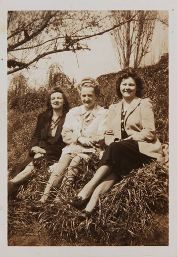 Three women sitting on riverbank