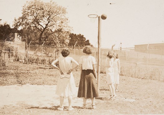Four women around basketball hoop
