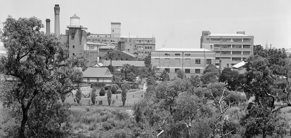 River in foreground with multi-story industrial building on far bank.