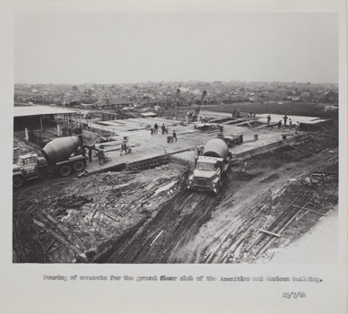 Construction site with concrete mixer trucks in the foreground