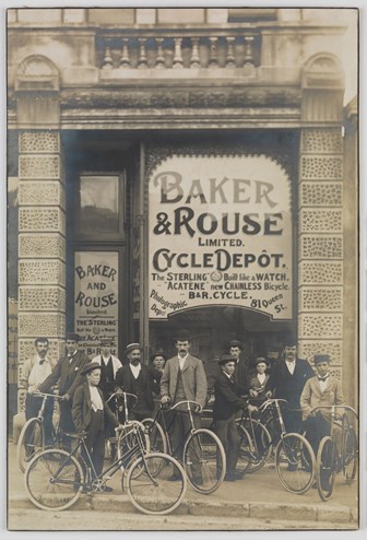 People with bicycles standing outside store