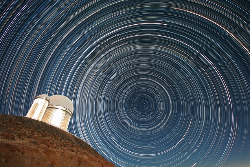 Telescope in front of a full sky of circular star trails