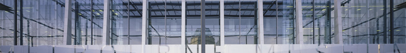 People in front of the glass facade of a building