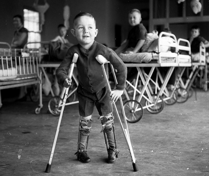A young boy on crutches with leg braces