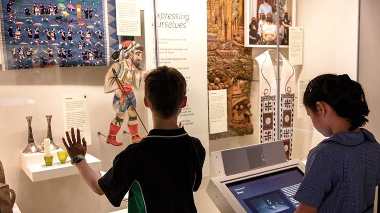 Two school children peering into a exhibition showcase