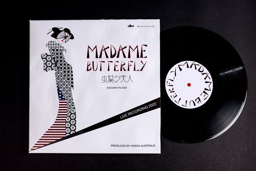 A vinyl record is shown outside its sleeve. Both have text reading ‘Madame Butterfly’. The record sleeve has an illustration of a geisha wearing a patterned dress, with text reading ‘Live Recording 2022, Produced by Opera Australia’.