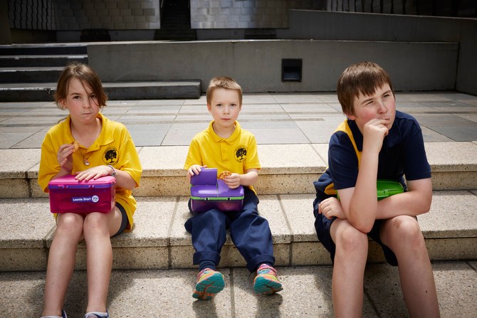 School Children with their lunchboxes in Immigration Museum courtyard.