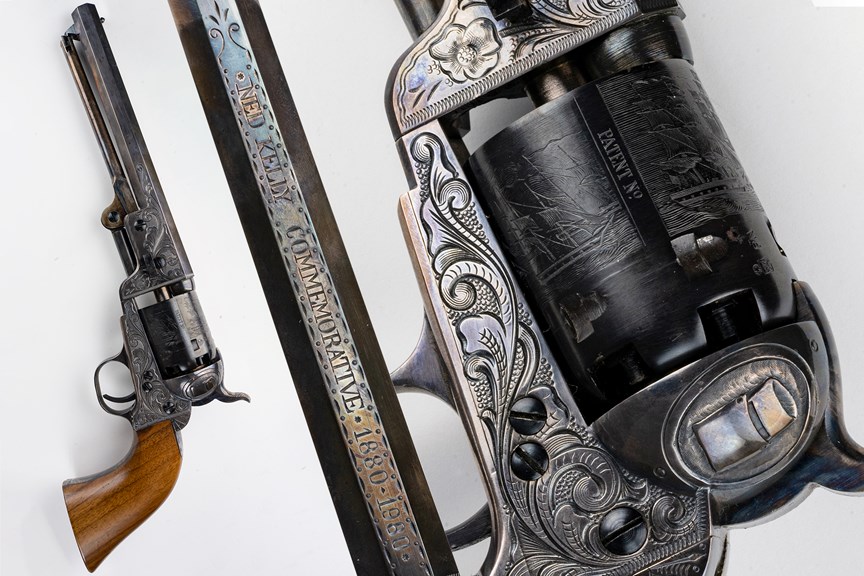 a composite photograph of a revolver firearm, highlighting its delicate engravings. The top of the barrel reads "Ned Kelly Commemorative 1880 - 1980"