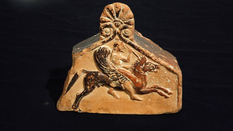 Photo of a clay sculpture featuring someone riding a winged horse