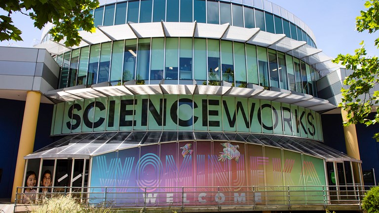 a circular building covered with colourful illustrations and the word Scienceworks