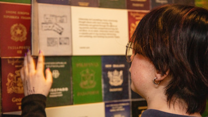 Secondary school student looking at the Passport wall in Identity: Yours, Mine, Ours exhibition in Immigration Museum.