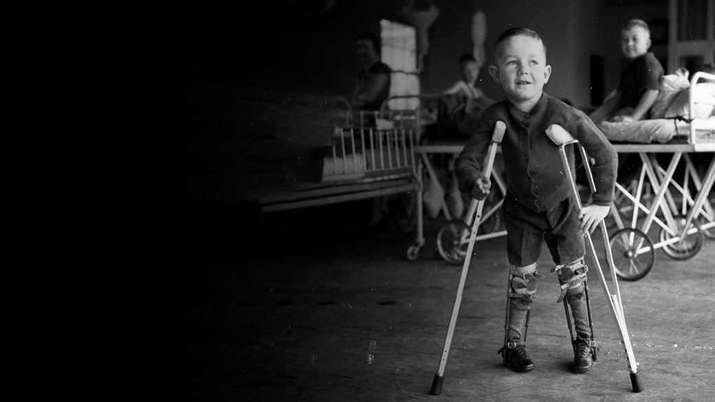 Small boy on crutches with legs in callipers