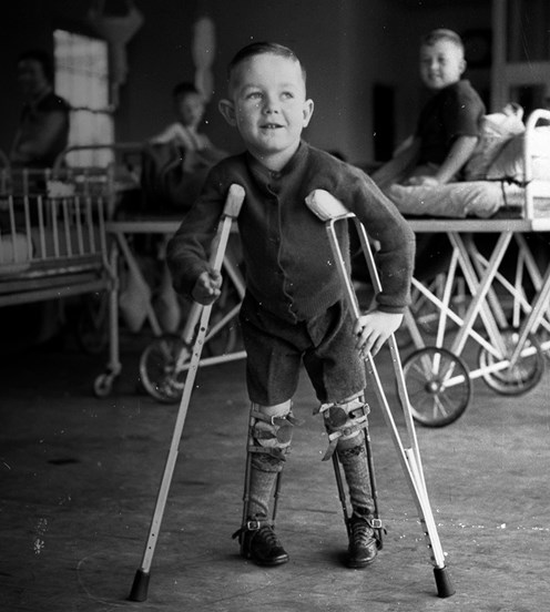 Small boy on crutches with legs in callipers