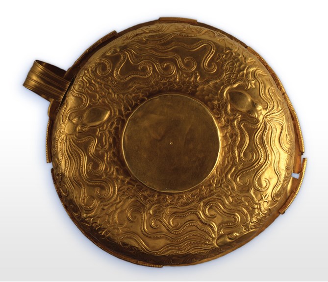 Overhead view of gold cup  with octopus carvings