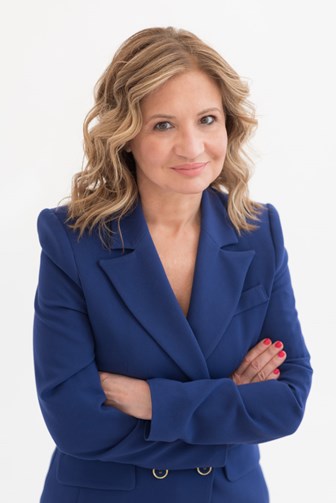 Portrait photo of Dr. Anna Vasiliki Karapanagiotou - she has her arms folded and wears a blue suit jacket