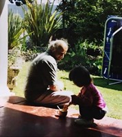 Man and small child sitting on veranda.