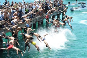A large crowd diving off a pier