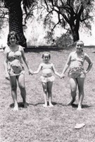 Three girls in swimmers holding hands