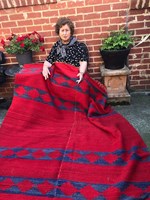 Woman holding a really large red blanket