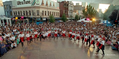 Children on stage dancing surrounded by large crowd
