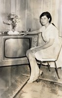 Woman sits next to a TV
