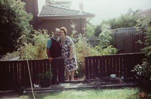 Couple stand proudly in the garden in front of their home