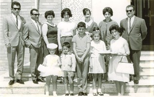Two families stand on the steps of a church