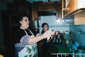 A old woman and a young girl cook together.
