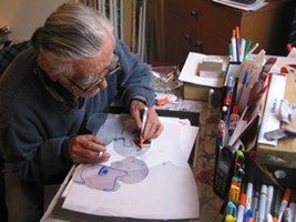 A man draws at a table.