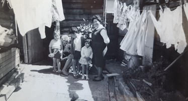 A woman and her children stand amongst washing lines.