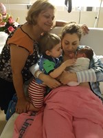 Woman holding baby in hospital bed.