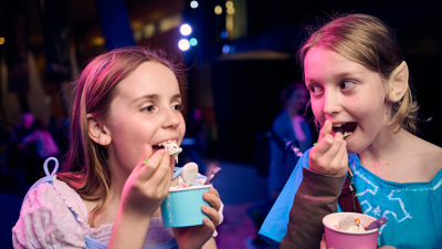 Two girls dressed up eating spooky themed sundaes