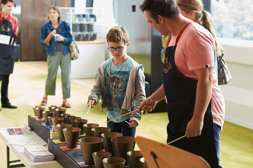 Young child being shown how to play the Federation Handbells