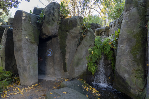a cave next to a small waterfall