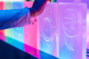 A hand graps a transparent tablet featuring a cartoon character