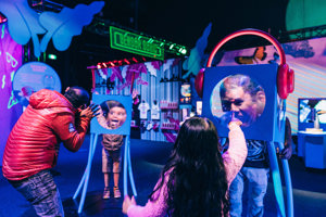 A family plays with fresnel lenses to distort their faces.
