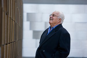 An older visitor views the memorial wall in the Tribute Garden at the Immigration Museum