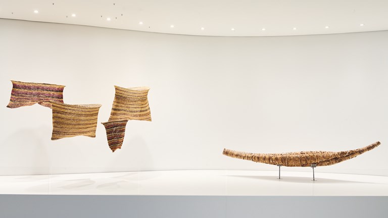 Artworks in a gallery: four fish nets and a canoe