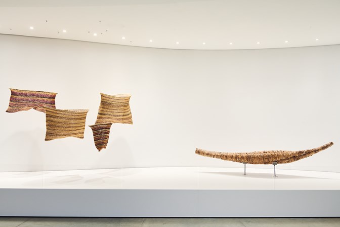 Artworks in a gallery: four fish nets and a canoe