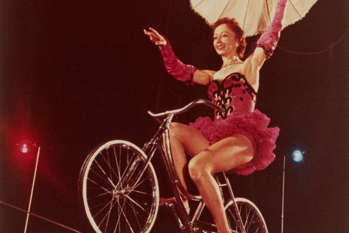 Woman riding a bicycle on a tightrope