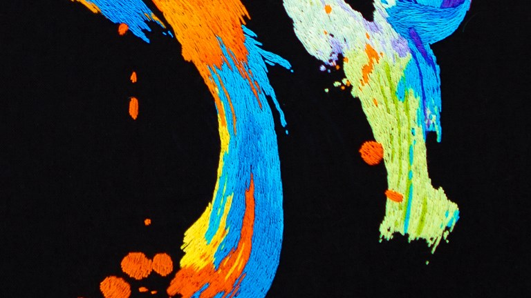 Brightly coloured embroidery on a black background
