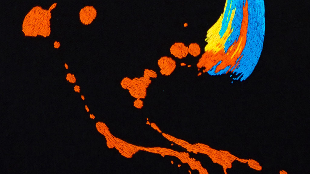 Brightly coloured embroidery on a black background
