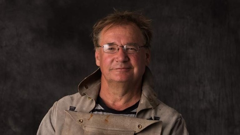 Portrait of a bespectacled man against a black background