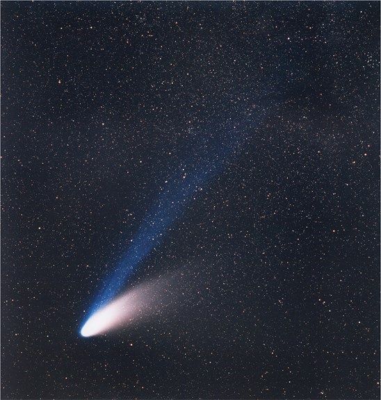 A comet with dust tail on the right and blue ion tail above