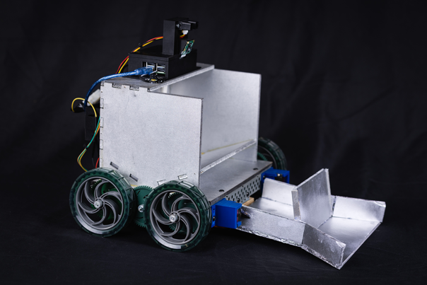 A photograph of a silver system with wheels, a black battery and wires. 