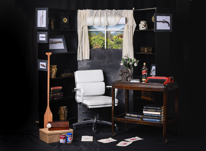 An old-fashioned office space, cluttered with various objects and a modern desk chair.