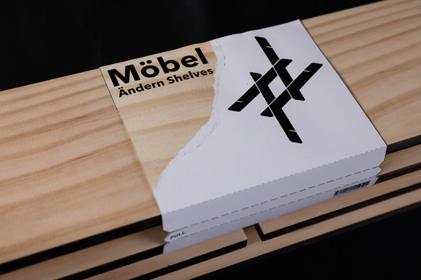 A close-up photo of wooden shelves. Packaging with text reading ‘Möbel Ändern Shelves’ is wrapped around the top of the shelves.