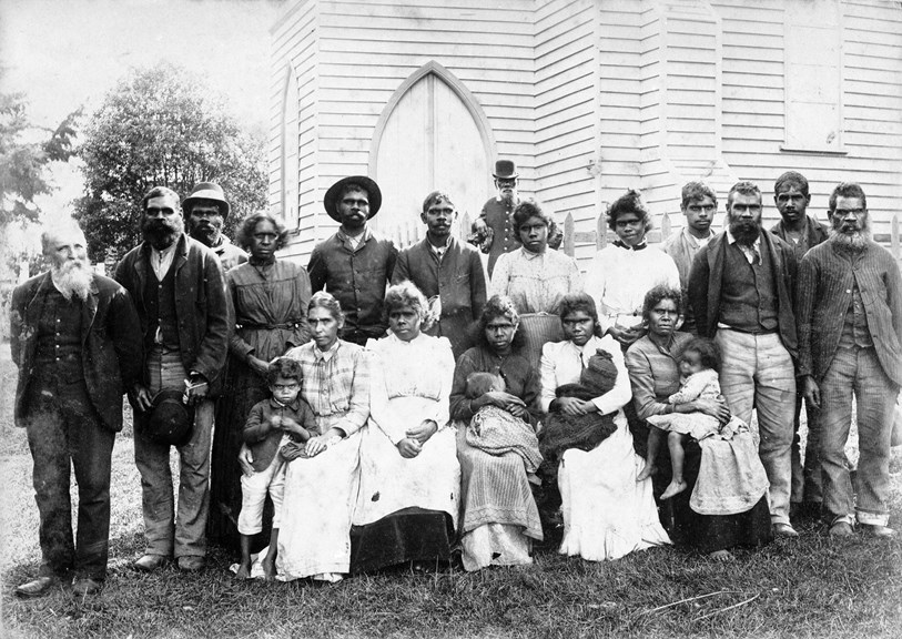 First Peoples residents (all unidentified) and Reverend John Bulmer, outside the church at Lake Tyers Mission, Gippsland on Gunai Kurnai Country, about 1886. 