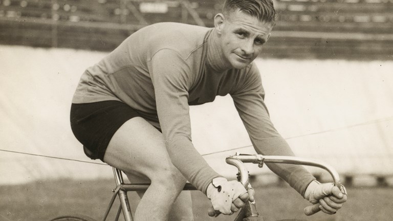 a sepia image of a man riding a bicycle