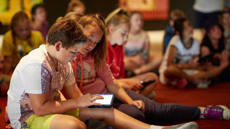 Primary school students sitting down with IPAD for the 'Our Shared History' program.